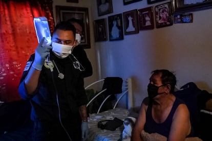 A paramedic gives an IV to an older adult, at his home located in the municipality of Nezahualcóyotl, State of Mexico, in November 2020.