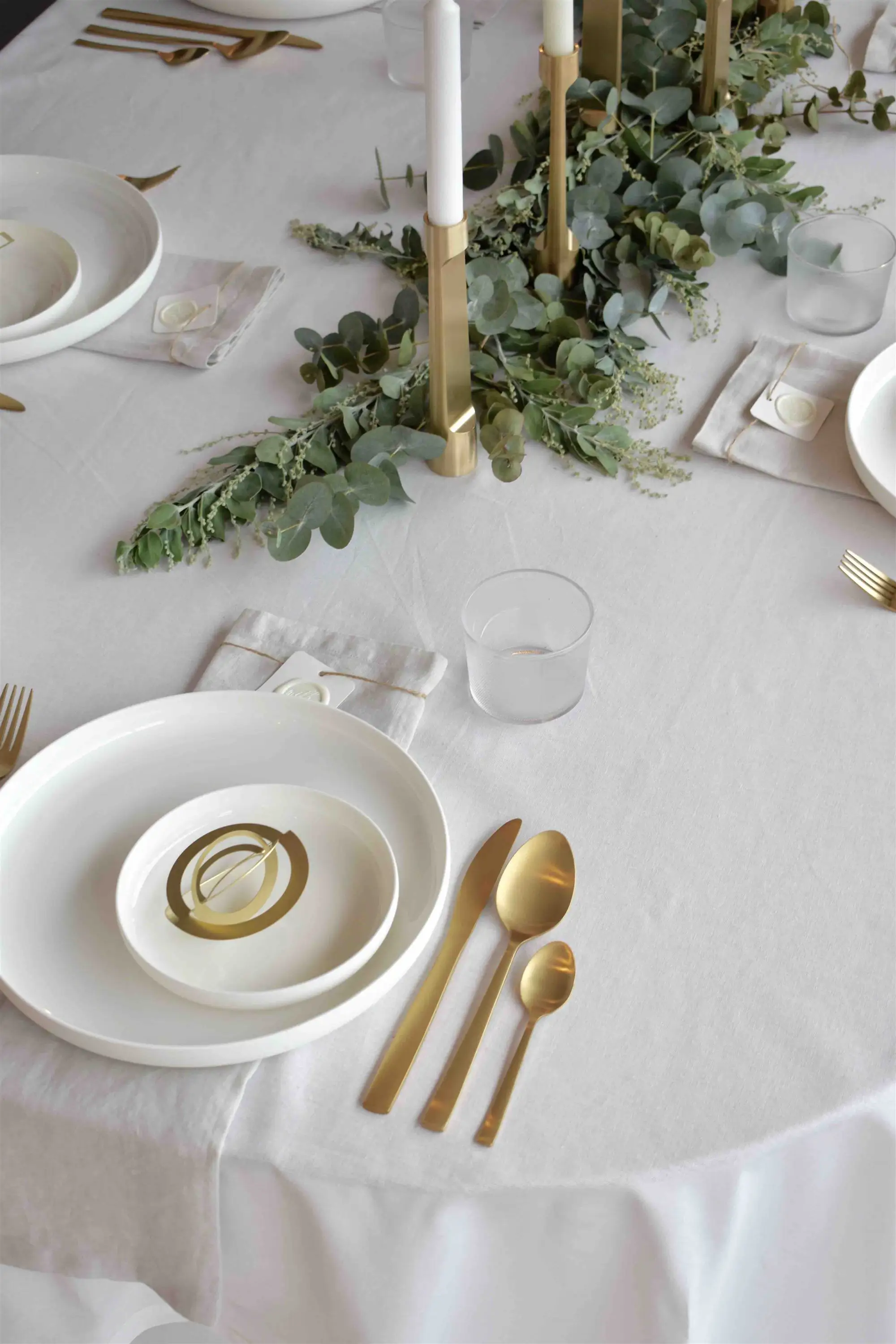 Christmas table with gold decoration and white tablecloth